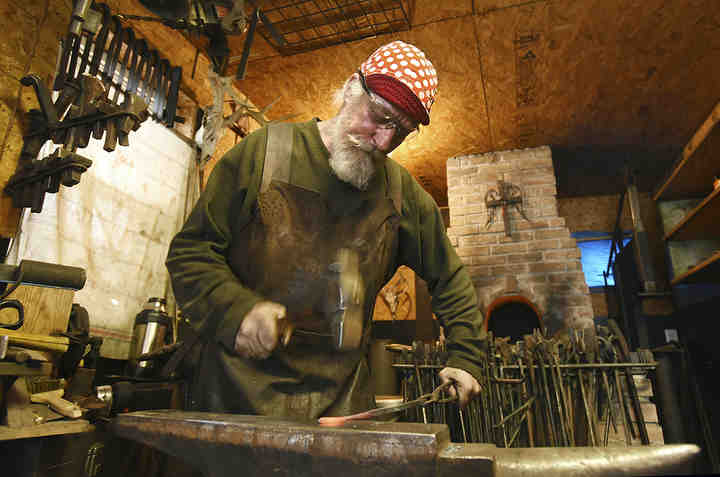 James Abrams hammers metal in his forge in Zanesville recently. Abrams creates a variety of metal items and sells them under the name Hillbilly Bling.  (Chris Crook / Zanesville Times Recorder)